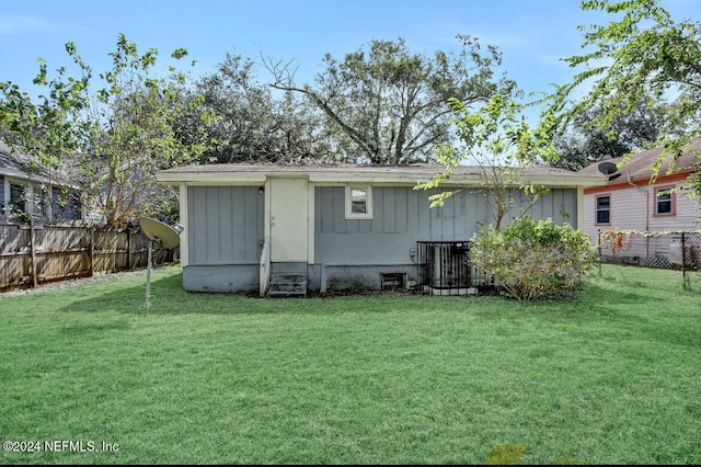 rear view of property featuring a yard