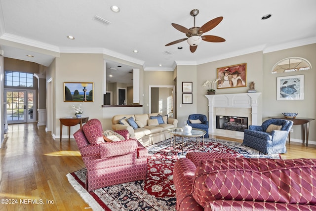 living room featuring light hardwood / wood-style floors, ceiling fan, and ornamental molding