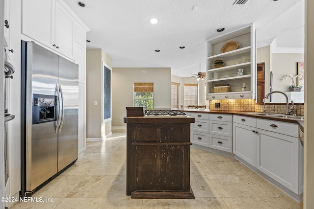 kitchen with sink, crown molding, decorative backsplash, white cabinetry, and stainless steel appliances