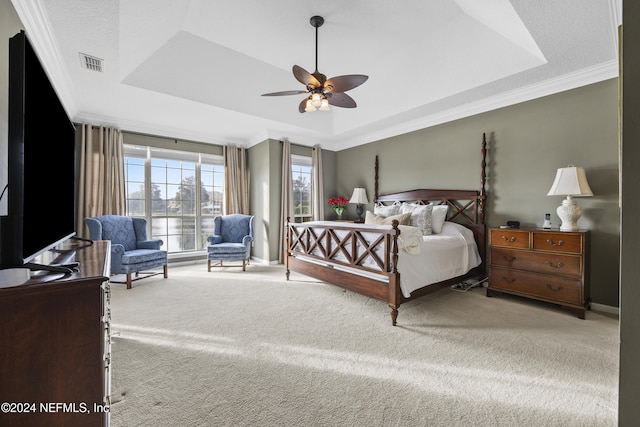 bedroom with ceiling fan, a raised ceiling, crown molding, and light carpet