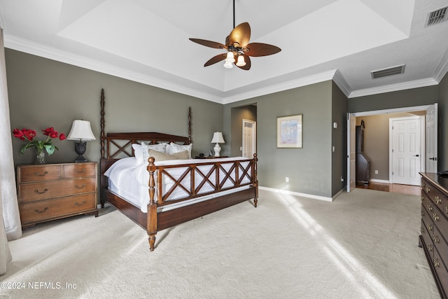 bedroom featuring light carpet, a tray ceiling, ceiling fan, and crown molding