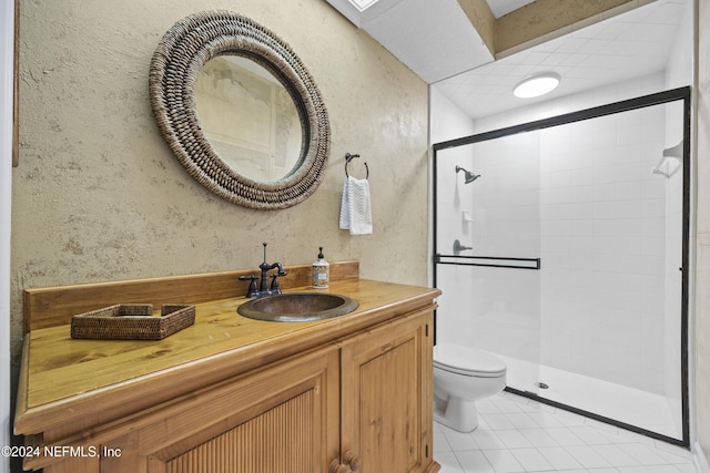 bathroom with toilet, tile patterned flooring, vanity, and walk in shower