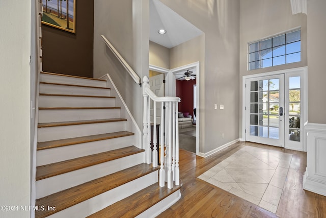 entryway with a towering ceiling, hardwood / wood-style flooring, and ceiling fan