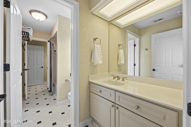 bathroom with a shower, tile patterned floors, vanity, and toilet