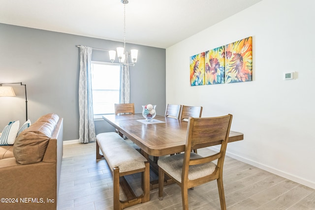 dining space featuring light wood-type flooring and a chandelier