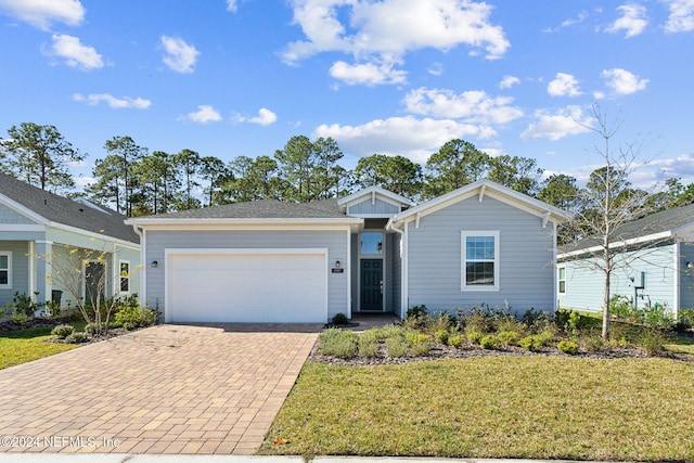 ranch-style home with a garage and a front lawn