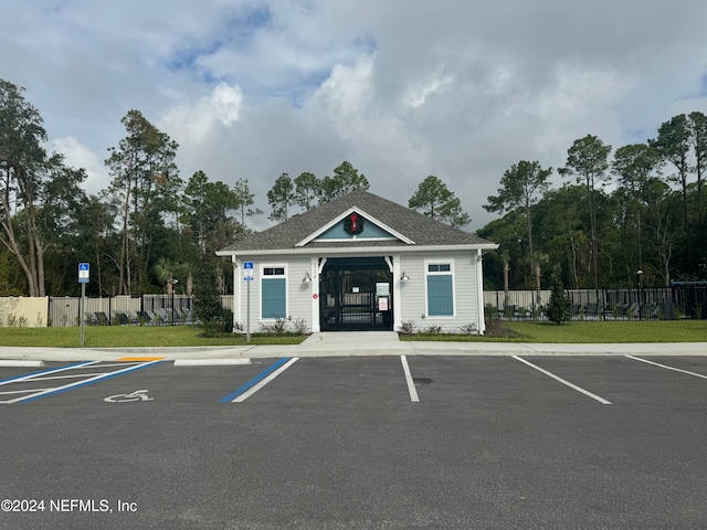 view of parking / parking lot featuring a lawn