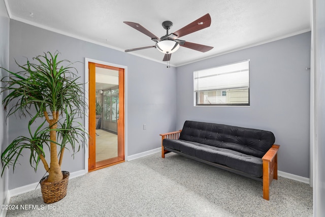 living area with carpet floors, ceiling fan, and crown molding