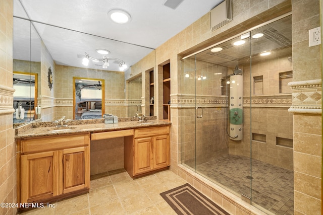 bathroom with vanity, an enclosed shower, and tile walls