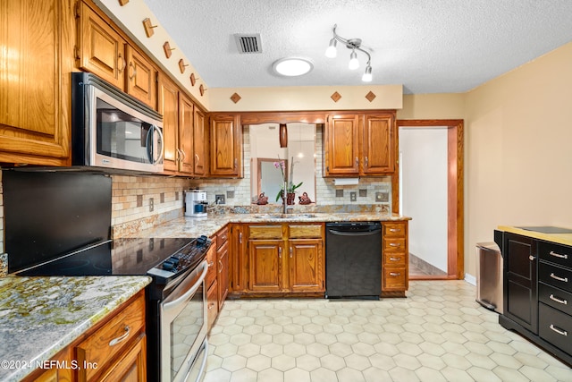 kitchen with a textured ceiling, sink, stainless steel appliances, and tasteful backsplash