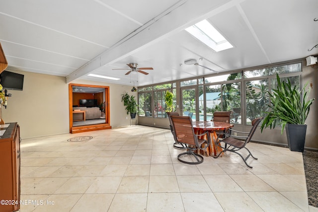 sunroom with beamed ceiling, a skylight, and ceiling fan