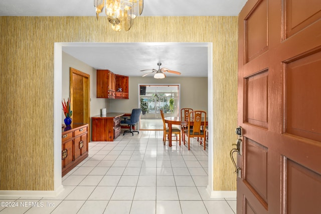 tiled foyer with ceiling fan with notable chandelier