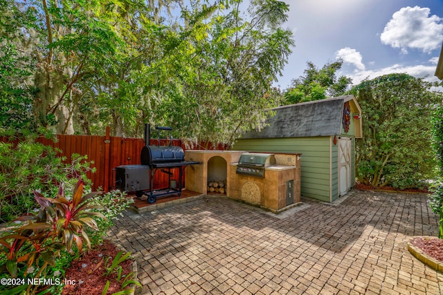 view of patio with an outdoor kitchen, grilling area, and an outdoor structure