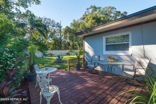 wooden terrace featuring a lawn