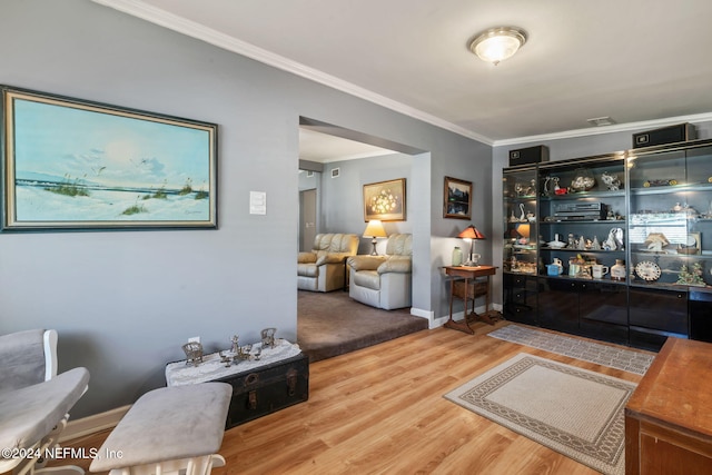 living room with wood-type flooring and crown molding