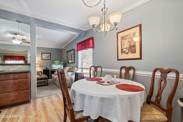 dining area with crown molding, ceiling fan with notable chandelier, vaulted ceiling, and light wood-type flooring