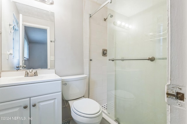 bathroom with an enclosed shower, vanity, and toilet