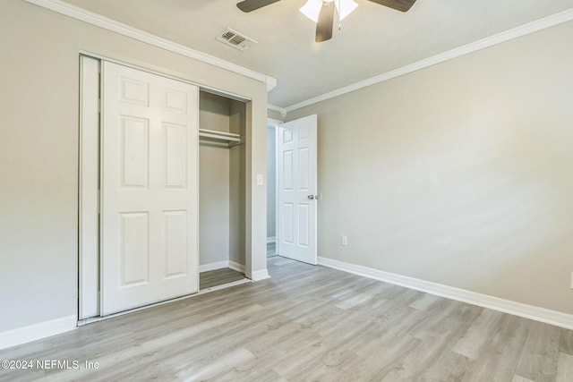 unfurnished bedroom featuring ceiling fan, light wood-type flooring, ornamental molding, and a closet