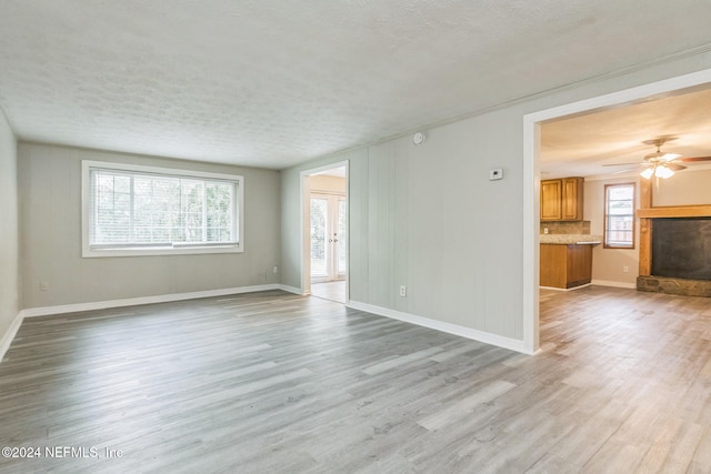 spare room with ceiling fan, a textured ceiling, and light wood-type flooring