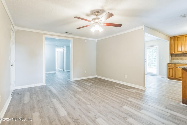 empty room featuring a textured ceiling, light wood-type flooring, ceiling fan, and crown molding