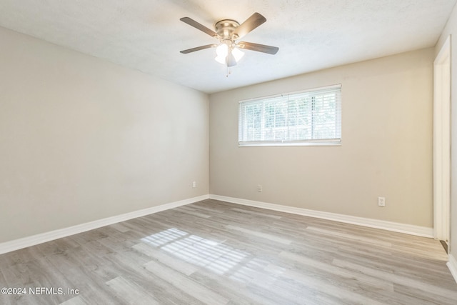 spare room with ceiling fan, a textured ceiling, and light wood-type flooring