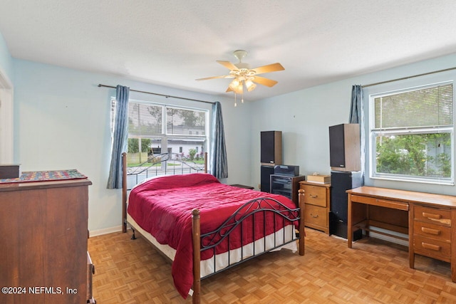 bedroom featuring light parquet flooring, a textured ceiling, and ceiling fan