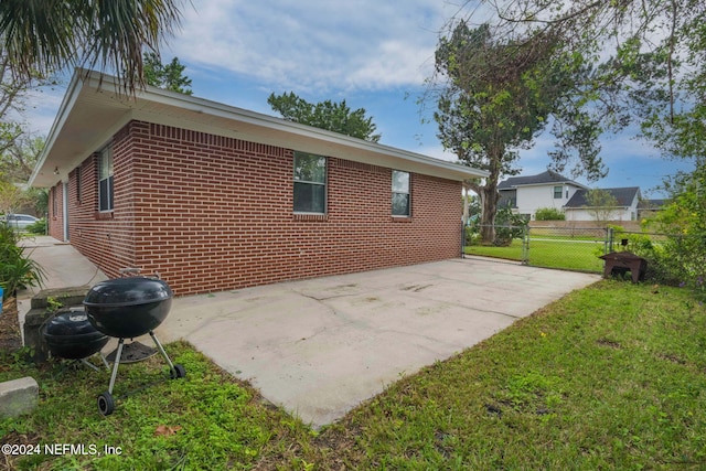 view of home's exterior with a yard and a patio area