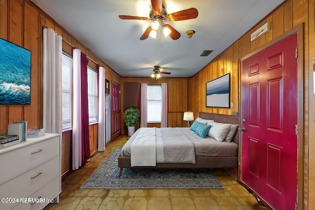 bedroom with wood walls and ceiling fan