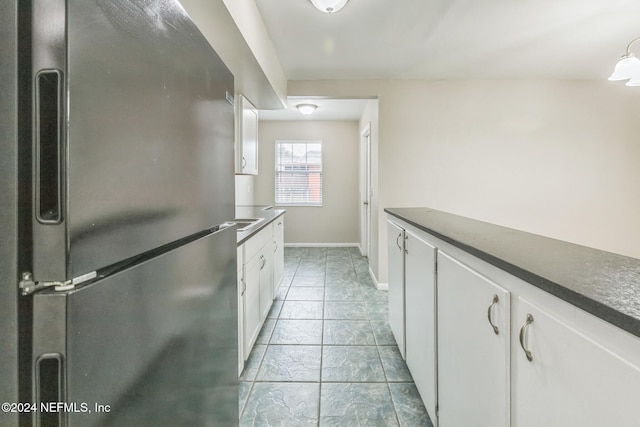 kitchen with stainless steel fridge and white cabinetry