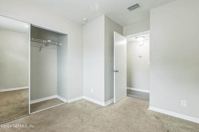 unfurnished bedroom with a closet and carpet