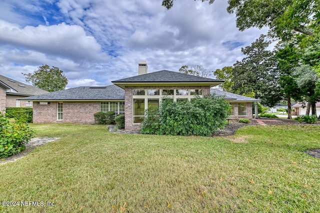 back of house featuring a sunroom and a yard