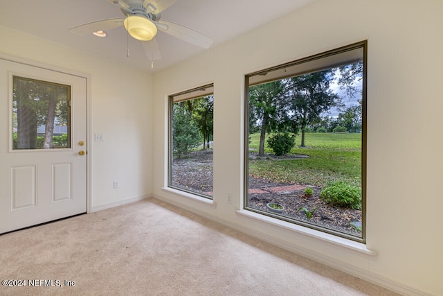 interior space featuring ceiling fan and light carpet