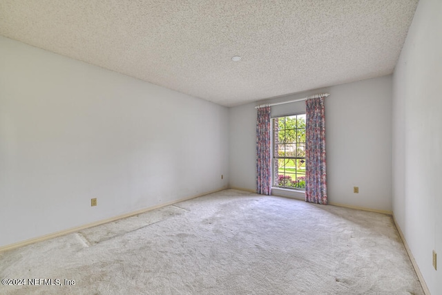 carpeted spare room with a textured ceiling