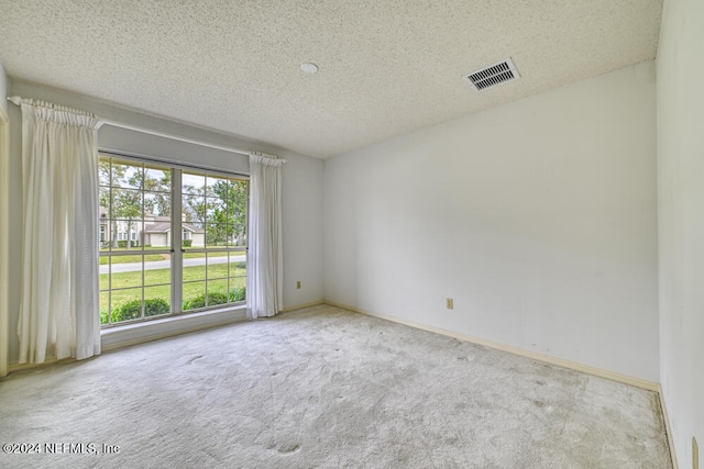 carpeted empty room with a textured ceiling