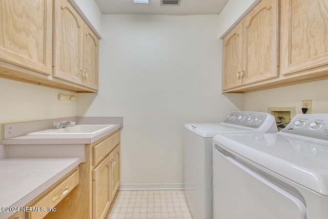 washroom featuring cabinets, a textured ceiling, and washing machine and clothes dryer