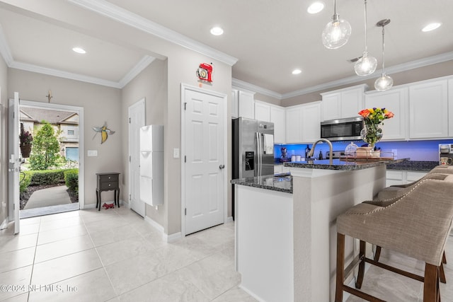 kitchen featuring stainless steel appliances, white cabinetry, decorative light fixtures, and ornamental molding