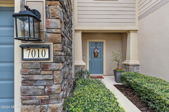 entrance to property with stone siding and stucco siding