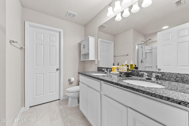 bathroom featuring tile patterned floors, toilet, a textured ceiling, an enclosed shower, and vanity