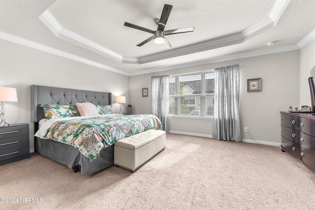 carpeted bedroom featuring ceiling fan, a textured ceiling, a raised ceiling, and crown molding