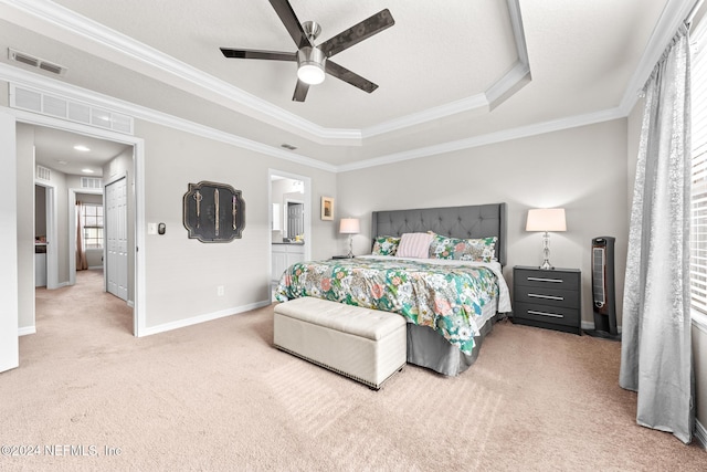 bedroom with ceiling fan, a raised ceiling, carpet flooring, and crown molding