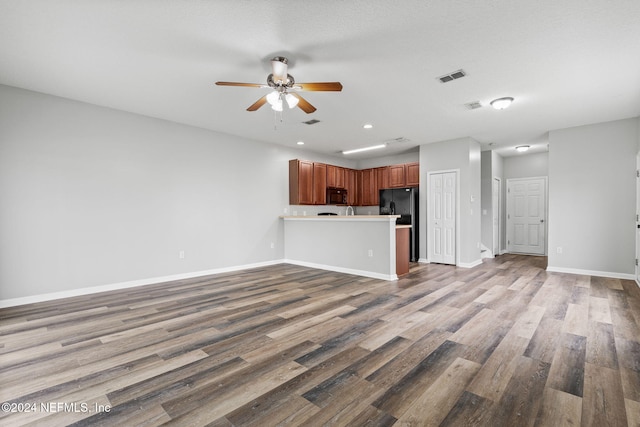 unfurnished living room with light wood-type flooring, a textured ceiling, and ceiling fan