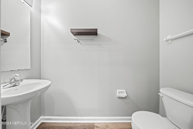 bathroom featuring toilet, sink, and hardwood / wood-style floors