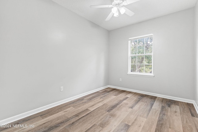 empty room with a textured ceiling, ceiling fan, and light hardwood / wood-style flooring