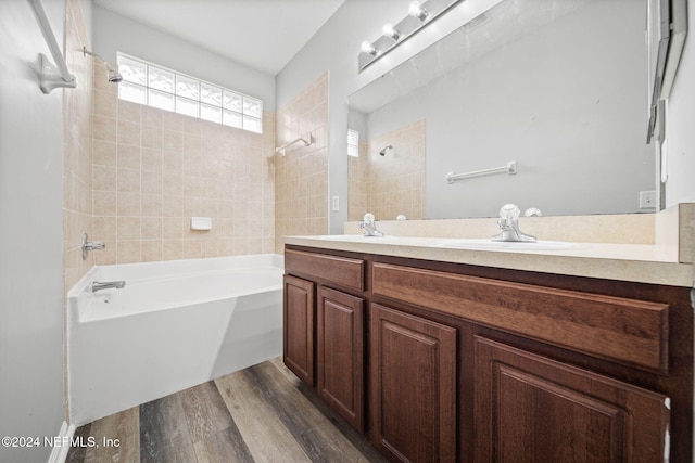 bathroom with vanity, tiled shower / bath, and wood-type flooring