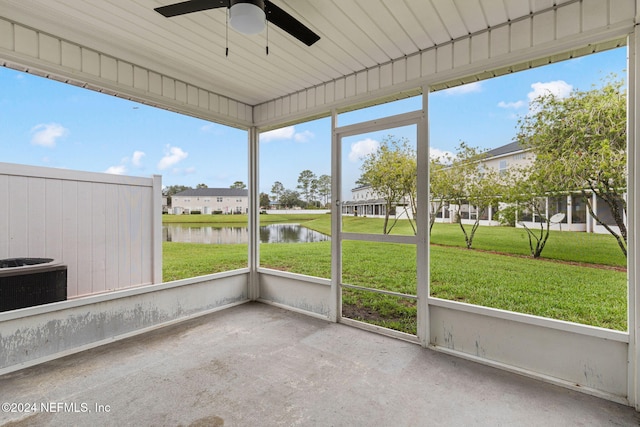 unfurnished sunroom with ceiling fan and a water view