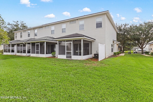 rear view of property featuring a sunroom and a yard