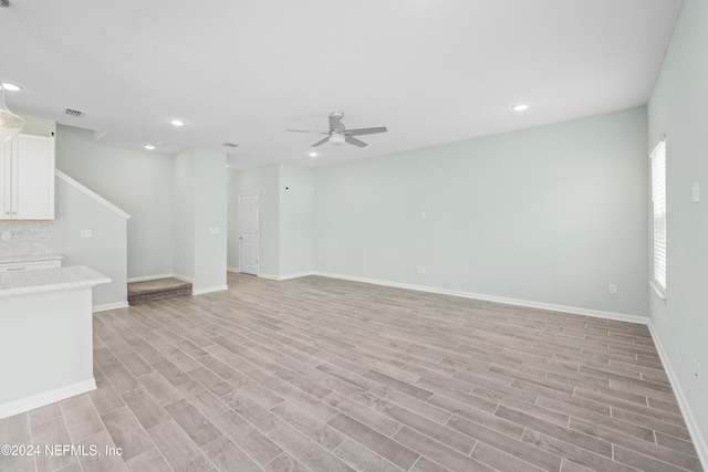 unfurnished living room with ceiling fan and light hardwood / wood-style floors