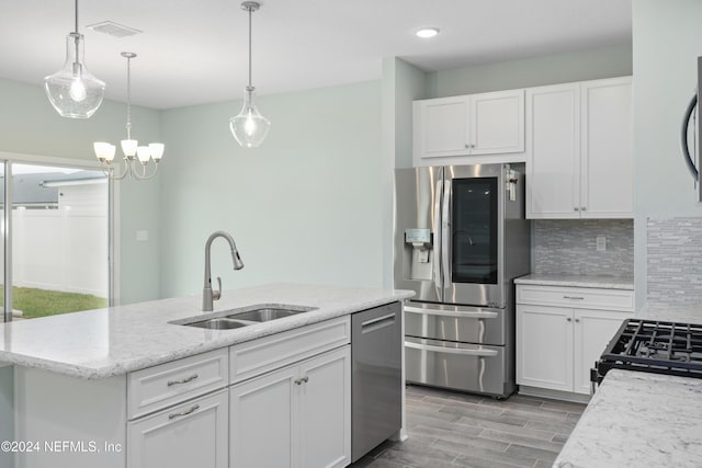 kitchen featuring an island with sink, sink, white cabinets, and stainless steel appliances