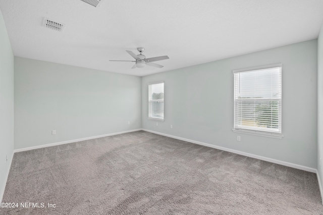 carpeted spare room featuring ceiling fan