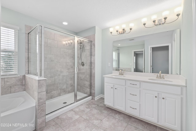 bathroom with tile patterned flooring, vanity, a healthy amount of sunlight, and separate shower and tub